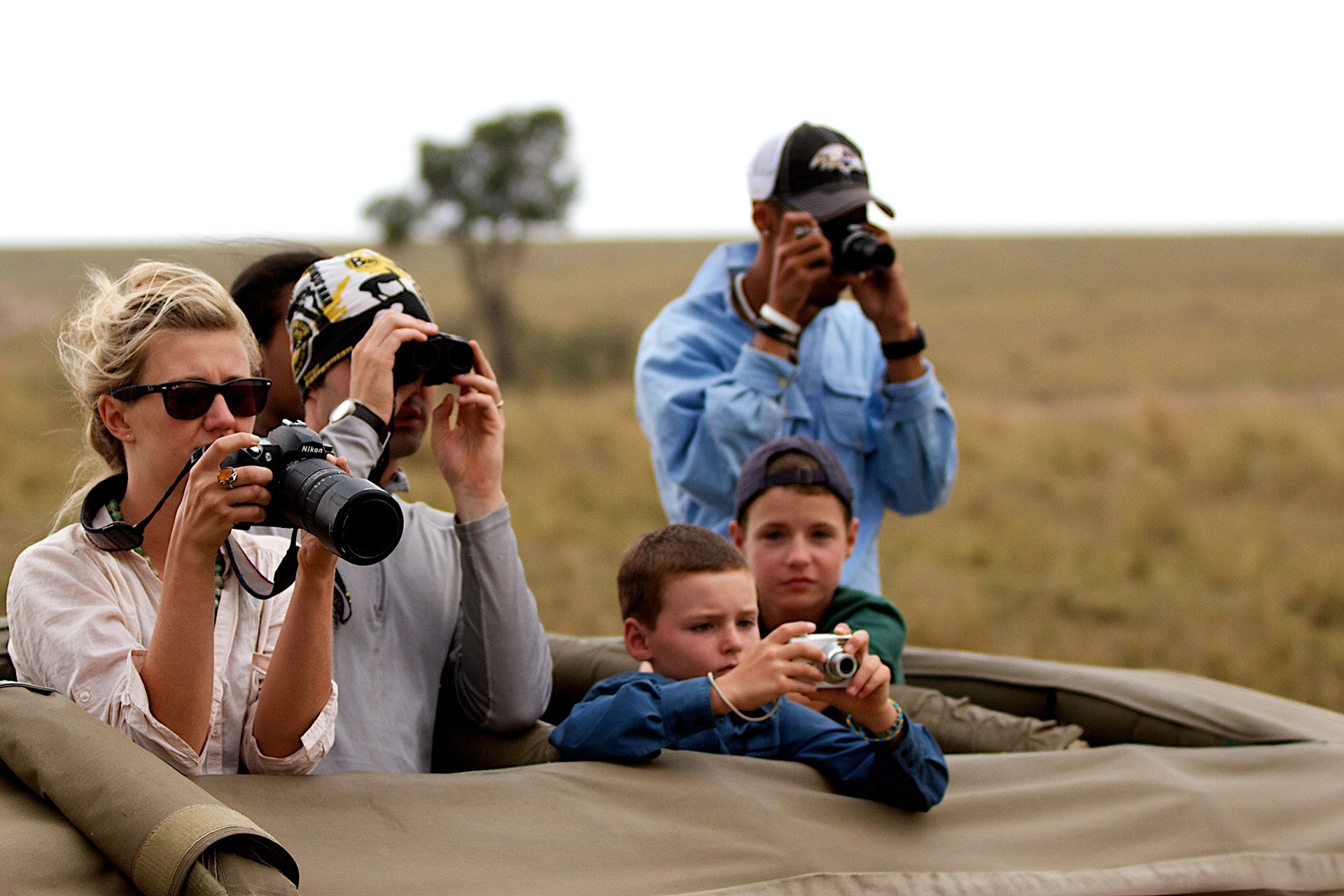 a family with cameras taking photos in a tanzania safari