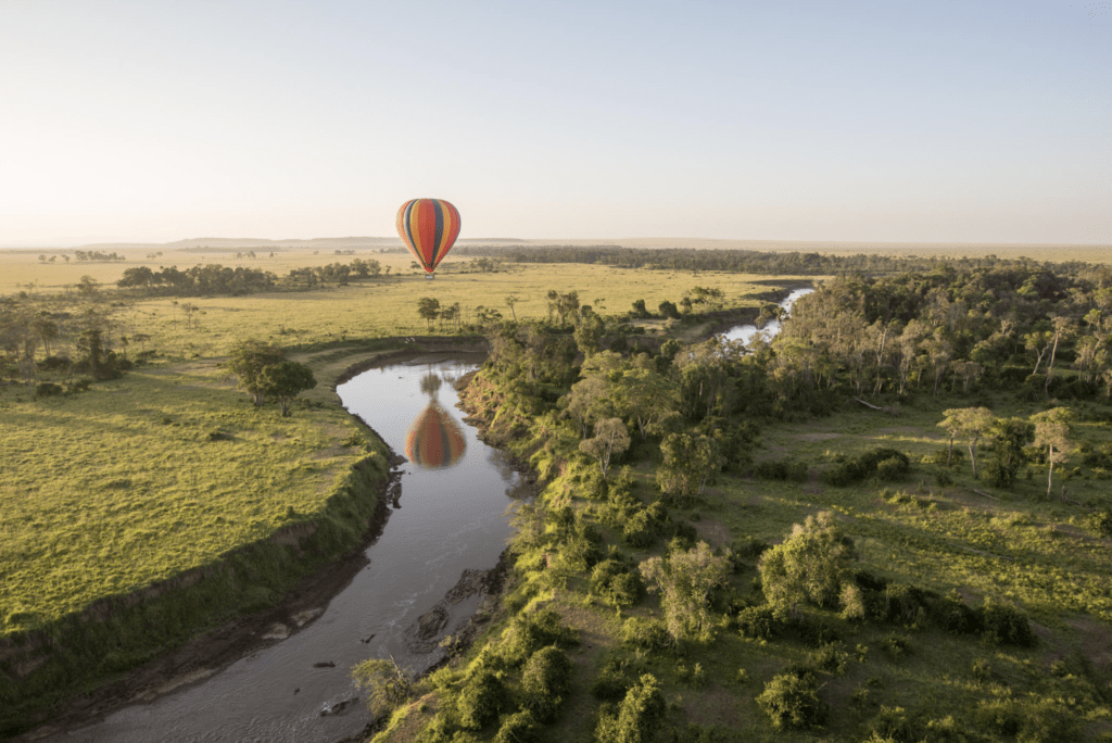 A hot air balloon hovering over a river in the Serengeti, providing a unique safari experience with breathtaking views.