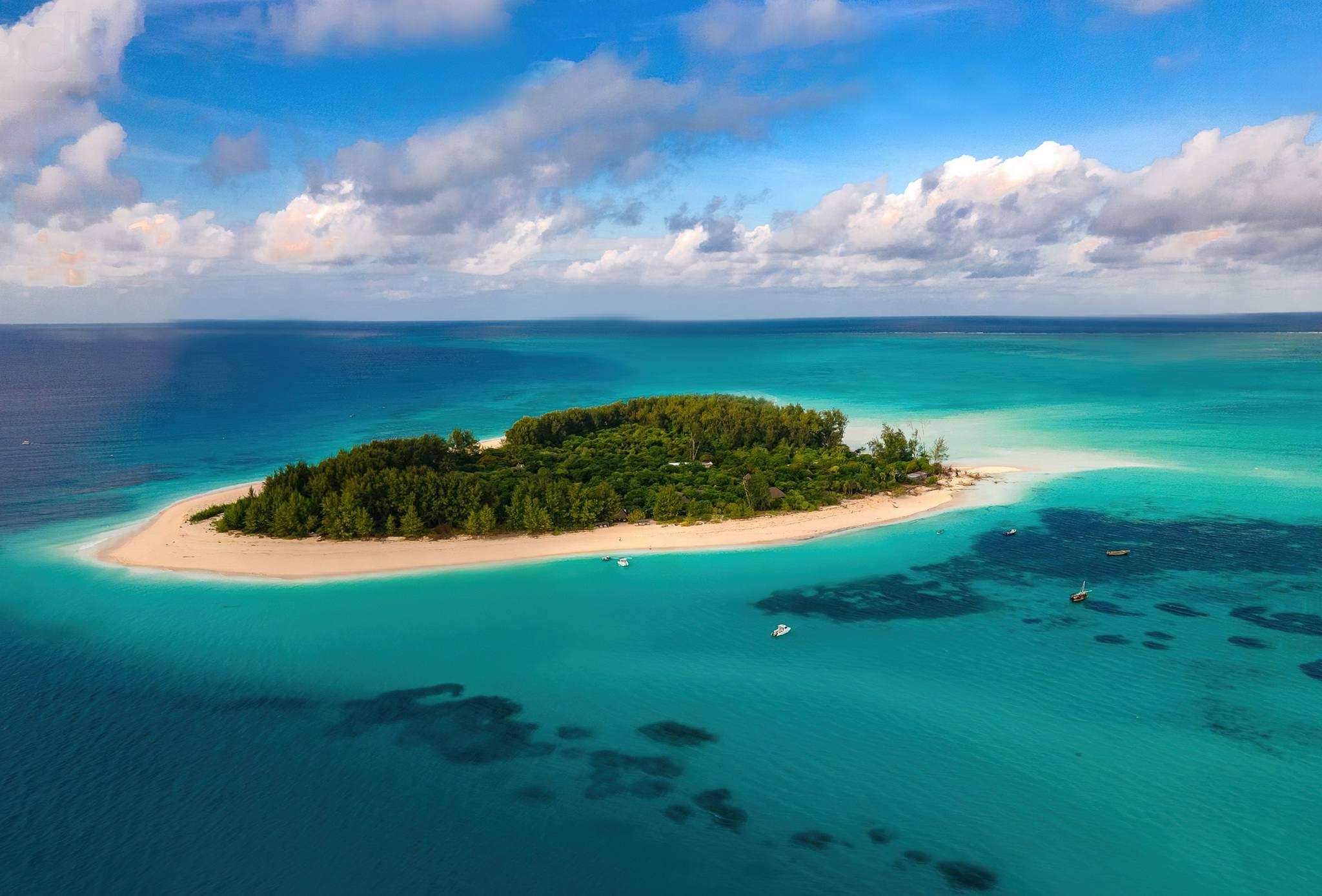 Aerial photo of Mnemba Island, Zanzibar, featuring turquoise waters and white sand beaches.