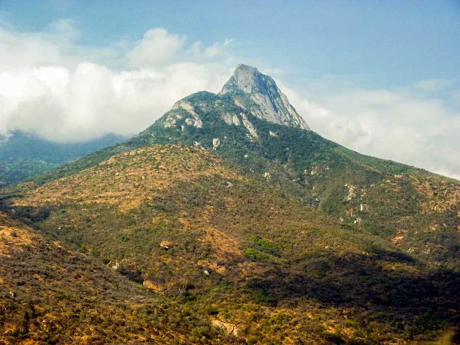 A distant view of Longido Mountain rising majestically above the surrounding plains in northern Tanzania, showcasing its rugged beauty and lush landscapes.