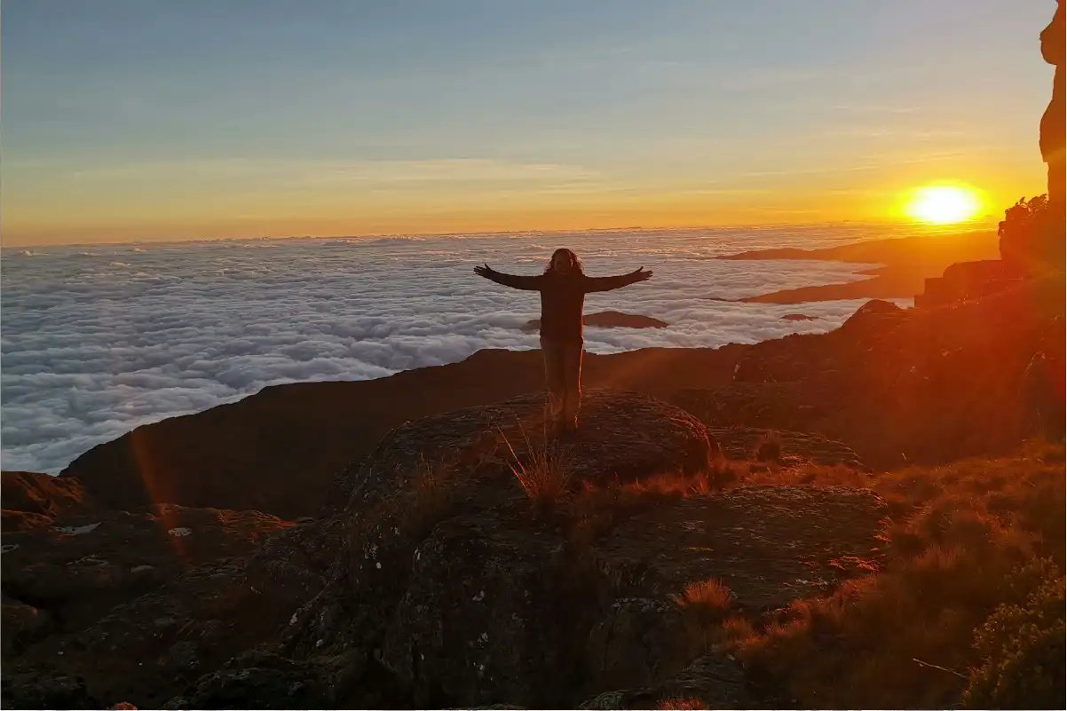 Climber at Uhuru Peak celebrating successful summit of Kilimanjaro