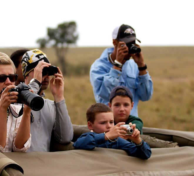 a family with cameras taking photos in a tanzania safari